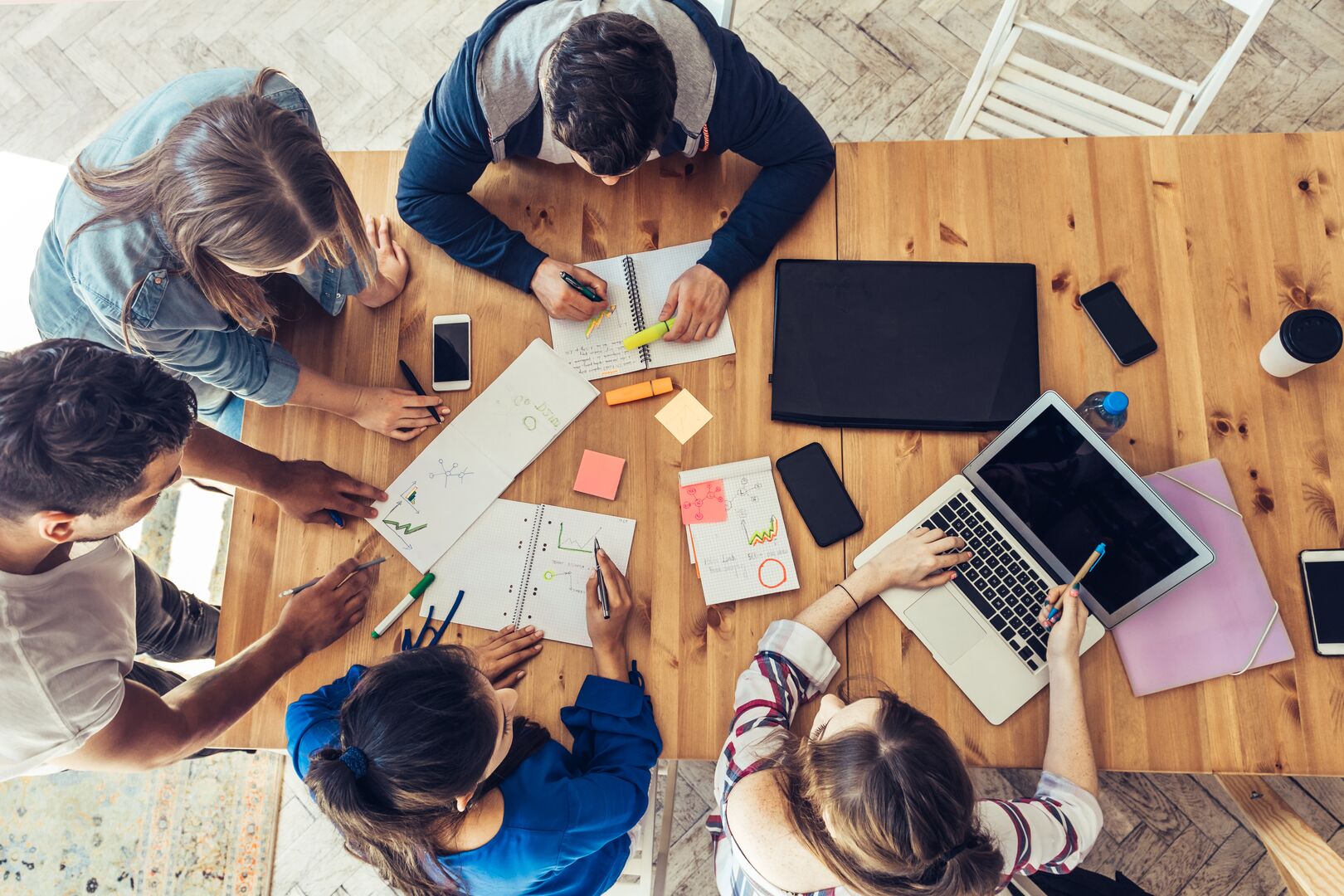 Overhead view on business people around wooden desk